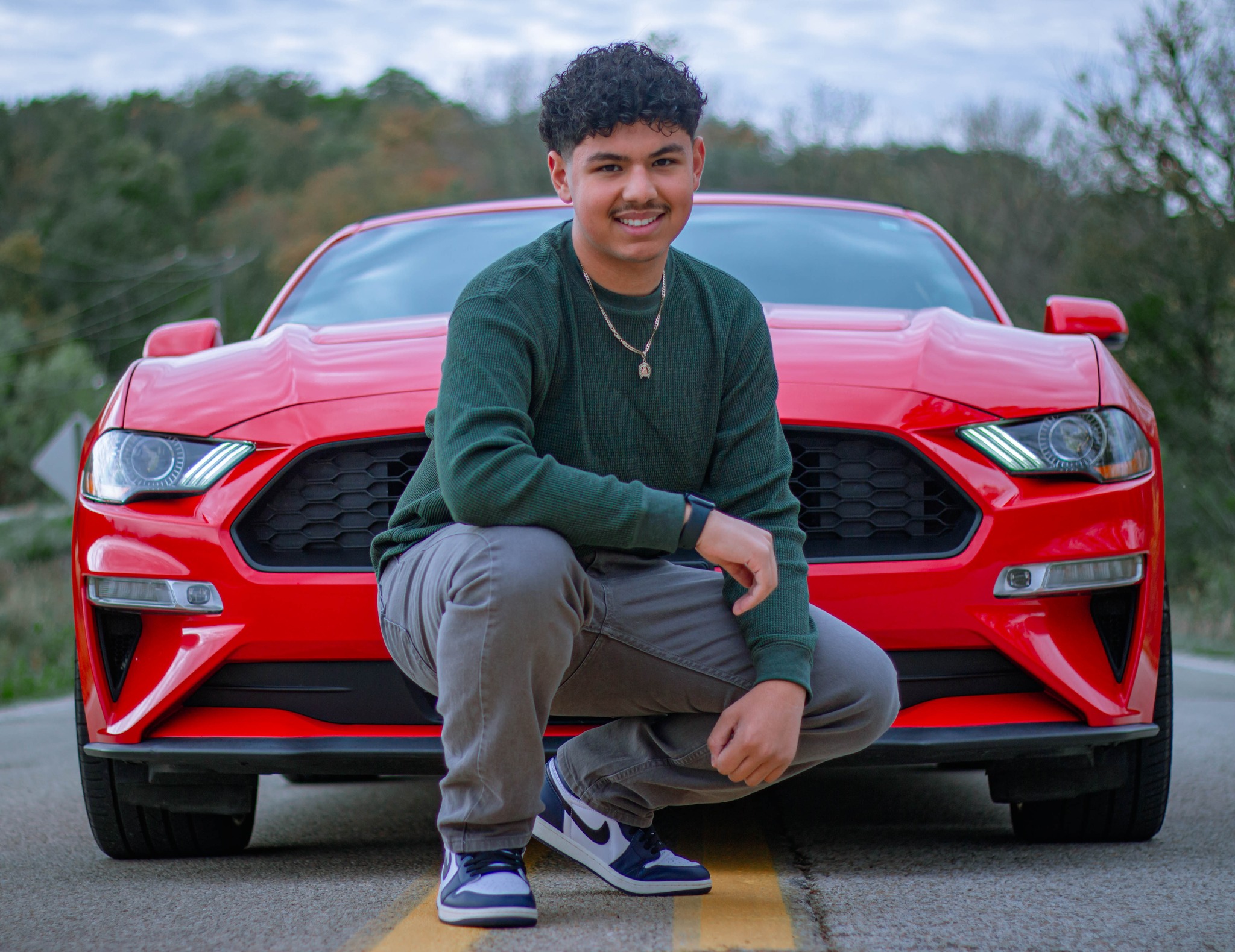 Senior portrait in front of a red Mustang
